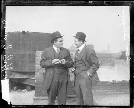 Boxer, James J. Jeffries holding a cigarette, standing with Sam Berger on the roof of a building - Chicago Daily News, Inc.