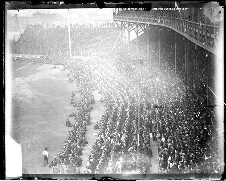 Crowds sitting on the field and in field-level seats, and sitting and standing in the grandstands - Chicago Daily News, Inc.