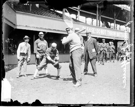 Boxer, James J. Jeffries holding a baseball bat, standing in a batting stance in foul territory - Chicago Daily News, Inc.