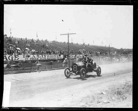Unidentified automobile driver driving an automobile past bleachers, during the Cobe Cup Race - Chicago Daily News, Inc.