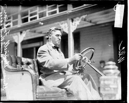Automobile driver G. Durrell sitting in the driver's seat of a Ford automobile parked in front of a building, during the Cobe Cup Race - Chicago Daily News, Inc.