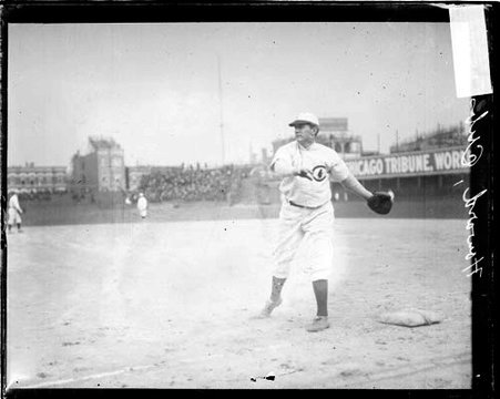 Baseball player Del Howard, Chicago Cubs, following through after throwing a baseball, standing at first base - Chicago Daily News, Inc.