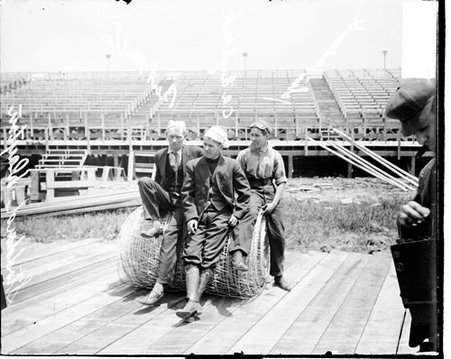 Automobile drivers Miller and Englebeck and auto mechanic John Harcombe sitting on a roll of mesh fencing during the Cobe Cup Race - Chicago Daily News, Inc.