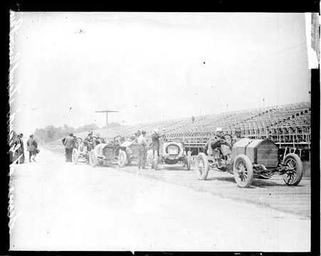 Men gathered around three automobiles parked in front of grandstands during the Cobe Cup Race - Chicago Daily News, Inc.