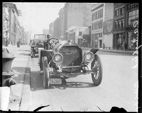 Automobile driver P. A. Englebeck facing the camera, sitting in an automobile parked on a street along a curb - Chicago Daily News, Inc.