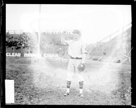 Baseball player Jack Knight, New York, pointing in the air, standing on the field at South Side Park - Chicago Daily News, Inc.