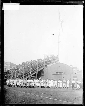 Chicago Cubs baseball players standing in front of a flagpole in the outfield during a pennant-raising ceremony at West Side Grounds - Chicago Daily News, Inc.