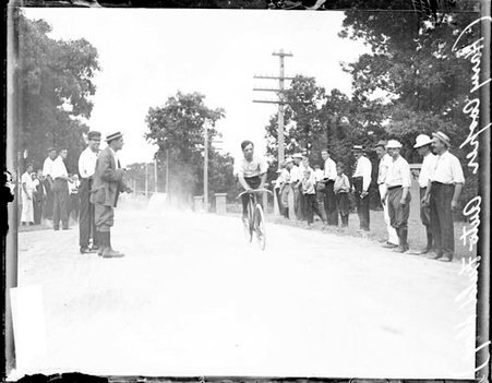 Cyclist Harry Cooper riding a bicycle on a during Auto Field Day - Chicago Daily News, Inc.