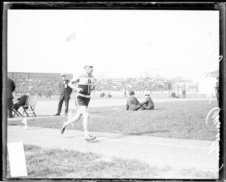 Athlete St. Yves running on the field at South Side Park during a marathon - Chicago Daily News, Inc.