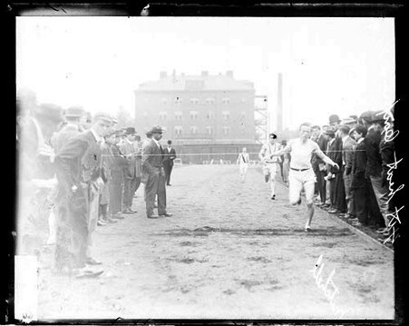 Athlete Mitchell racing towards the finish line on the track at Marshall Field - Chicago Daily News, Inc.
