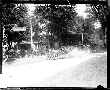 Automobile driver George Robinson driving a Locomobile automobile on a road during the Cobe Cup Race - Chicago Daily News, Inc.