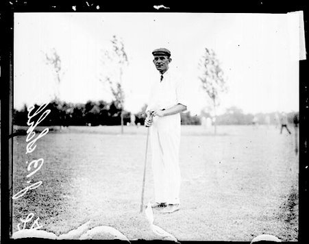 Golfer J. B. Schlotman holding a golf club in front of him on the grounds of an unidentified golf course - Chicago Daily News, Inc.