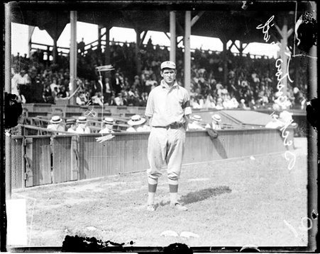 Baseball player Beck, Boston, standing in front of field-level seats and grandstands on the field at West Side Grounds - Chicago Daily News, Inc.