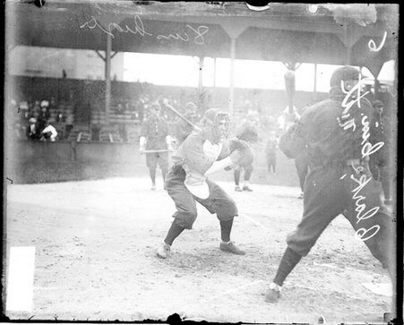 Catcher Clarke, Cincinnati, crouching in a ready position behind home plate at West Side Grounds - Chicago Daily News, Inc.