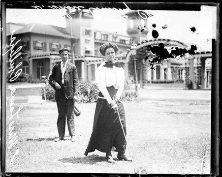 Golfer Miss Laura Phillips holding a golf club, standing on the grounds of the South Shore Country Club - Chicago Daily News, Inc.