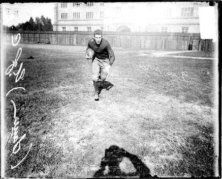 University of Chicago football player Sauer holding a football and running towards the camera on the field at Marshall Field - Chicago Daily News, Inc.