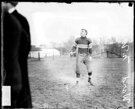 Northwestern University football player Ward looking up, standing on an athletic field - Chicago Daily News, Inc.