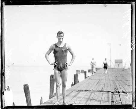 Swimmer Dick Frizzle, involved in a swimming marathon in the Chicago River, standing on a dock - Chicago Daily News, Inc.