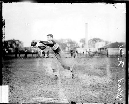 Northwestern University football player Ward catching a football on an athletic field - Chicago Daily News, Inc.