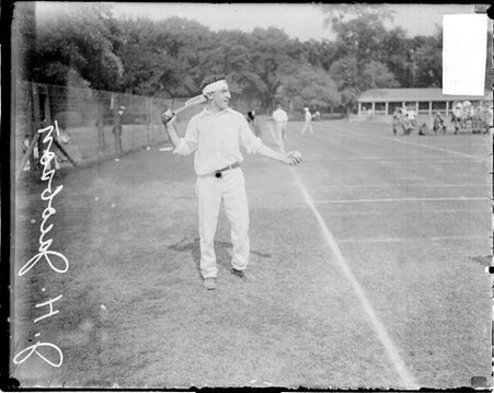 Tennis player J. H. Jacobson, holding a tennis ball in front of him and a tennis racket behind his head at the Aztec Tennis Club - Chicago Daily News, Inc.