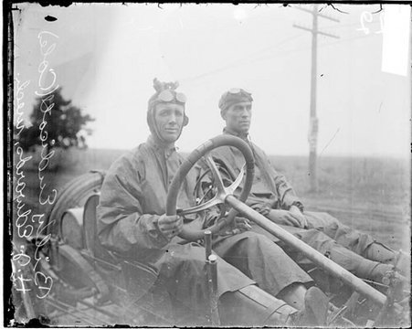 Automobile driver Billy Endicott and automobile mechanic H. J. Edward sitting in a Cole automobile parked outdoors in Elgin - Chicago Daily News, Inc.