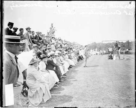Crowds sitting in courtside bleachers during a tennis tournament at the Onwentsia Club in Lake Forest - Chicago Daily News, Inc.