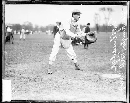 Washington Park Cong. catcher Tallmadge, standing in a ready fielding position behind a base on a baseball field - Chicago Daily News, Inc.