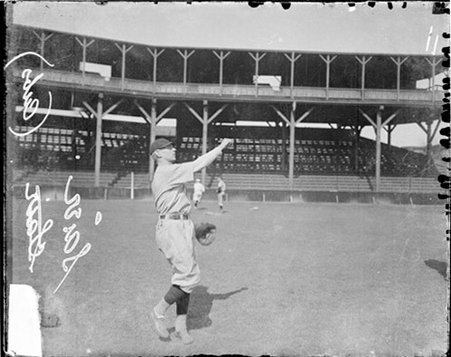 Baseball player Saier, Chicago Cubs, following through after throwing a baseball on the field at West Side Grounds - Chicago Daily News, Inc.