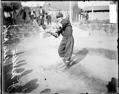 Lake High School baseball player Madden swinging a baseball bat on a dirt lot - Chicago Daily News, Inc.