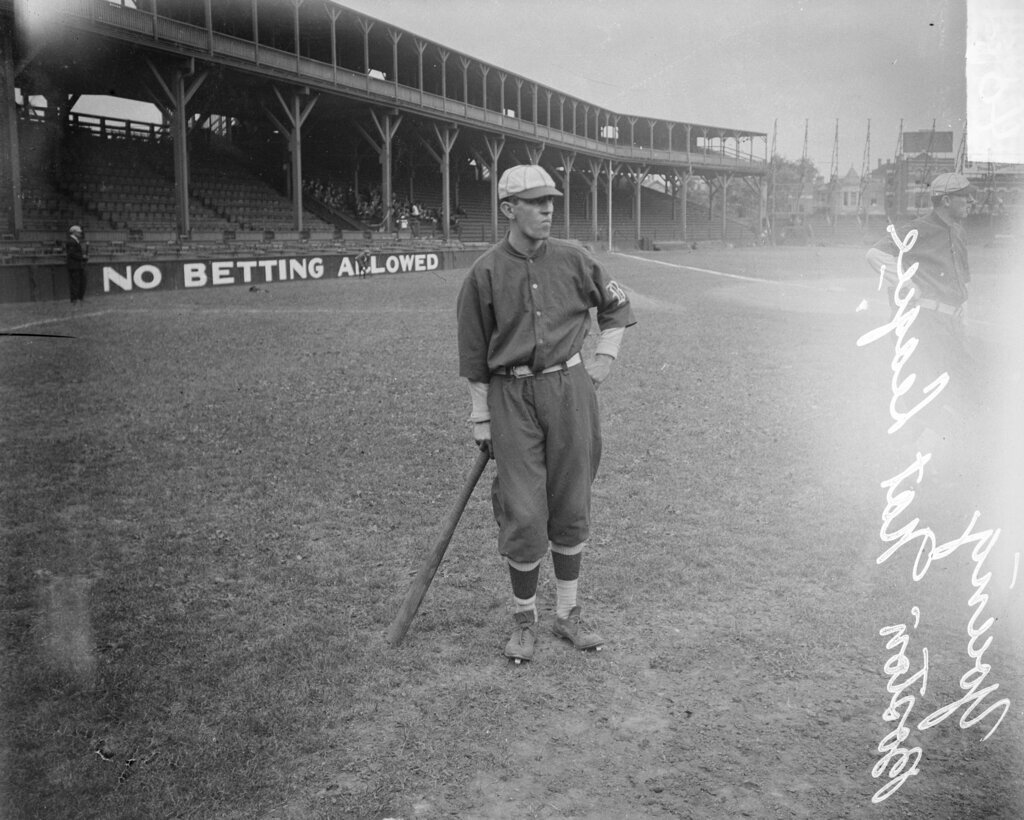 Baseball player Young, Boston Beaneaters, holding a baseball bat standing on the field at West Side Grounds - Chicago Daily News, Inc.