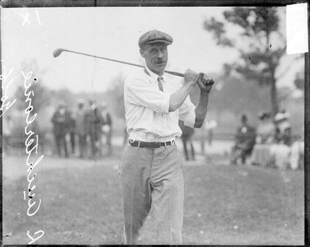 Golfer L. Auchterlonie following through after swinging a golf club - Chicago Daily News, Inc.