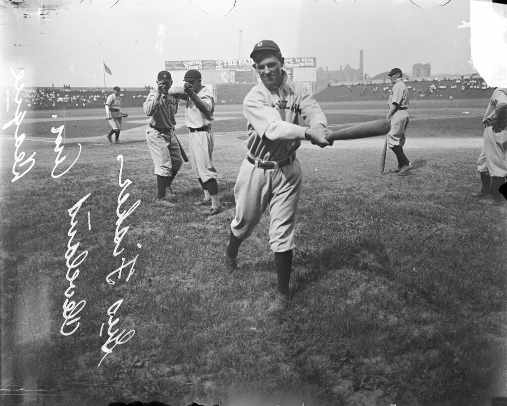 Baseball player Fisher, Cleveland Naps, holding a baseball bat in front of him, standing near home plate on the field at Comiskey Park - Chicago Daily News, Inc.