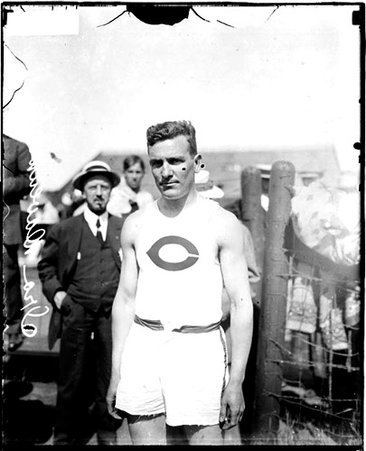 Runner Ira Davenport standing on an athletic field - Chicago Daily News, Inc.
