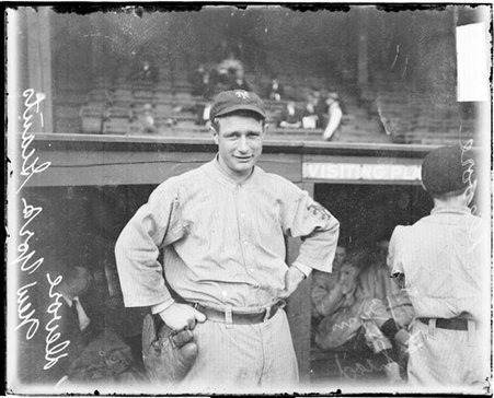 Baseball player, Devore, New York Giants, standing in front of the visitors' dugout on the field at West Side Grounds - Chicago Daily News, Inc.