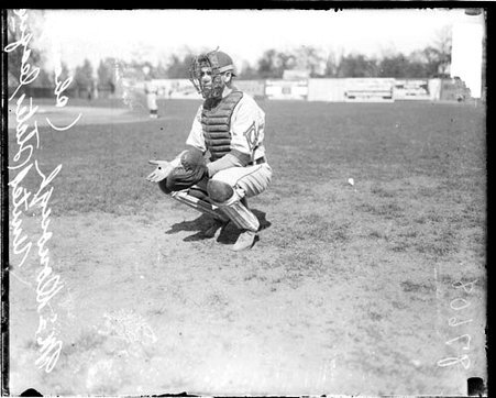 U. S. League baseball catcher McDonough crouching in a catching position on a baseball field - Chicago Daily News, Inc.