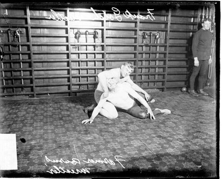 Wrestler Gotch wrapping his arm around the head of wrestler Farmer Burnsin a room - Chicago Daily News, Inc.