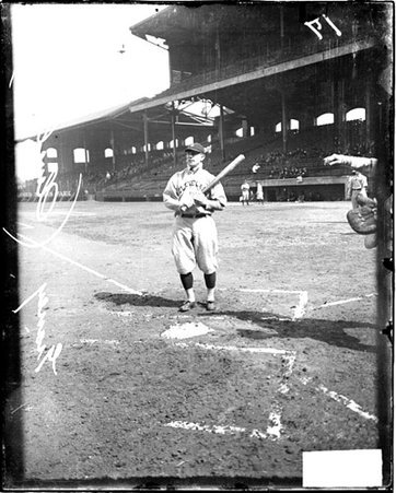 Baseball player Graney of Cleveland Naps, holding a baseball bat at home plate on the field at Comiskey Park - Chicago Daily News, Inc.
