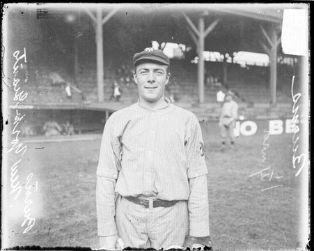 Baseball player, Burns, New York Giants, standing in front of grandstands on the field at West Side Grounds - Chicago Daily News, Inc.