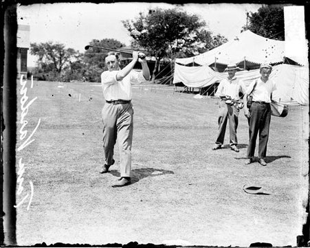 Golfer Varden following through after swinging a golf club - Chicago Daily News, Inc.