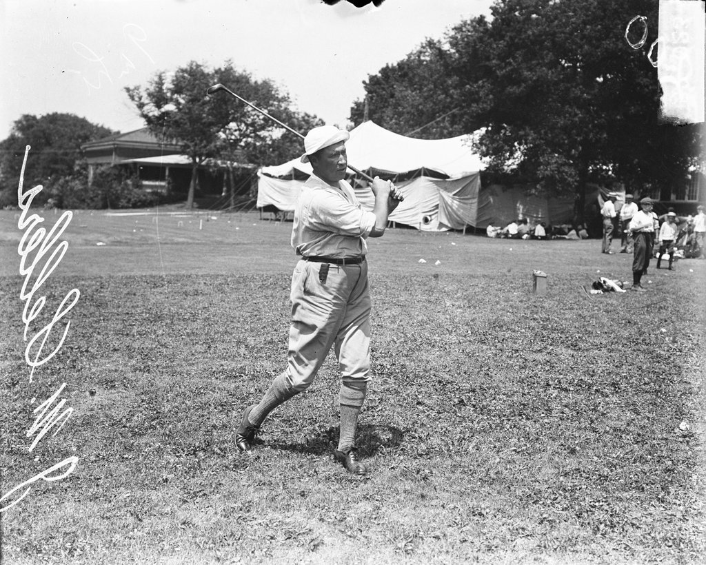 Golfer Sellers following through after swinging a golf club - Chicago Daily News, Inc.