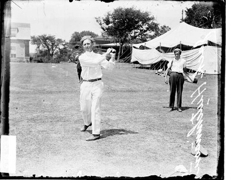 Golfer Hutchinson following through after swinging a golf club - Chicago Daily News, Inc.