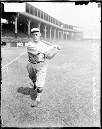 Baseball player, Hildebran, St. Louis Cardinals, following through after swinging a baseball bat on the field - Chicago Daily News, Inc.