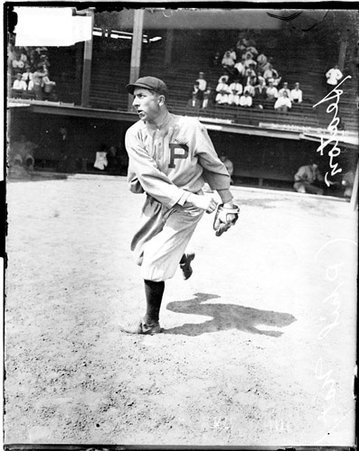 Baseball player, Seaton, Phillies, following through after throwing a baseball in front of a dugout - Chicago Daily News, Inc.