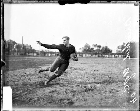 University of Chicago football player Hugh holding a football and running on the field at Marshall Field - Chicago Daily News, Inc.