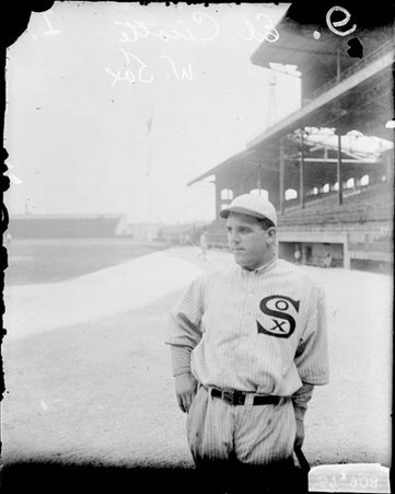 Baseball player Eddie Cicotte, White Sox, leaning on a baseball bat on the field at Comiskey Park - Chicago Daily News, Inc.