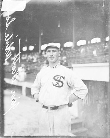 Baseball player Jim Scott, White Sox, standing in front of a dugout and grandstands on the field at Comiskey Park - Chicago Daily News, Inc.
