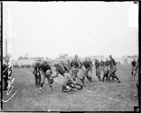 University of Chicago and Indiana football game, unidentified football player lunging towards another unidentified player who is holding a football - Chicago Daily News, Inc.