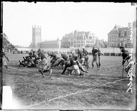 University of Chicago and Iowa football game, players grappling, standing, and running on the field at Marshall Field - Chicago Daily News, Inc.