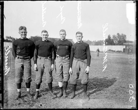 University of Chicago football players Russell, Breathed, Boyd, and McConnell standing on the field at Marshall Field - Chicago Daily News, Inc.