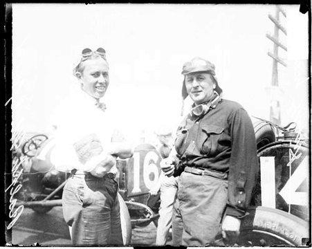 Automobile drivers, Ralph Mulford and H F Grant standing in front of parked automobiles on a road during Elgin Auto Races - Chicago Daily News, Inc.